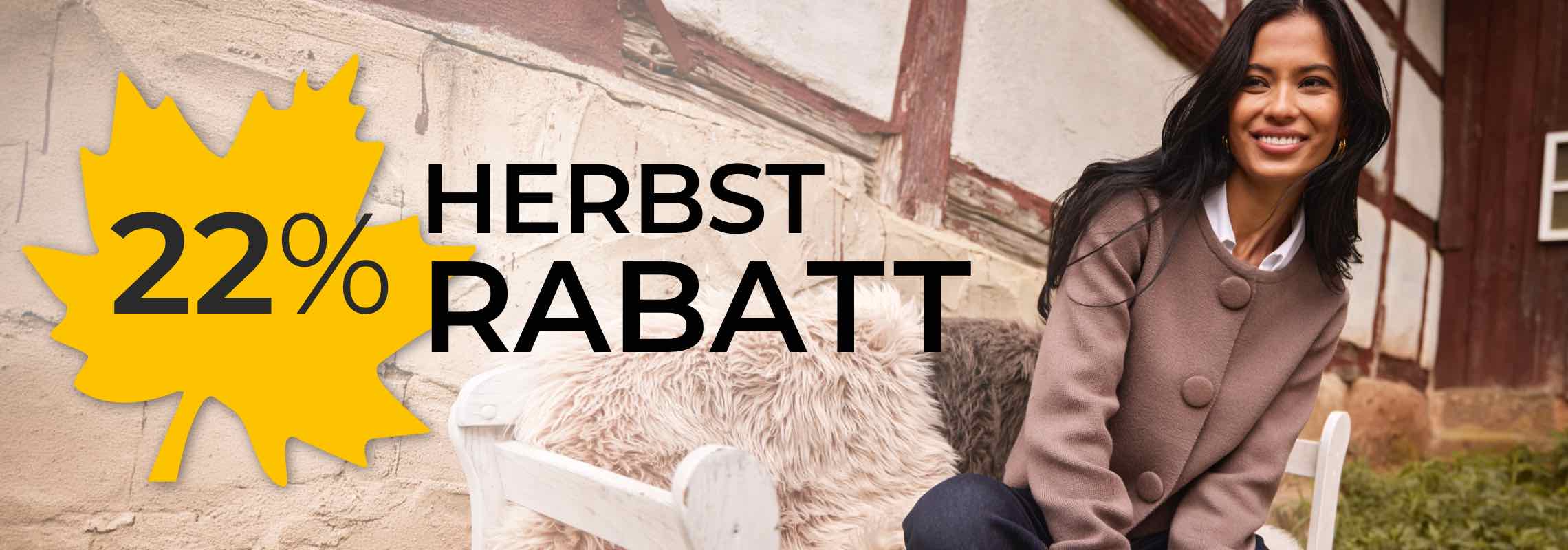 22 % Herbstrabatt auf einem gelben Blatt – lächelnde Frau im Mantel sitzt auf Bank vor Fachwerkhaus
